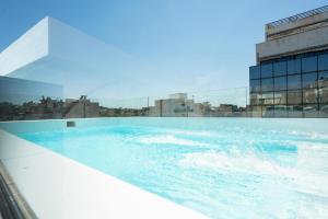 a hot tub on the roof of a building at Silk Athens Urban Collection in Athens