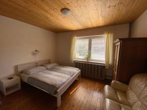 a bedroom with a bed and a window and a couch at Ubytování u Malinkovičů in Břeclav