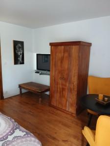 sala de estar con TV y armario de madera en vanoulou, en Drucourt