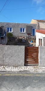 a house with a wooden fence in front of it at Casa do Meio in Nadadouro