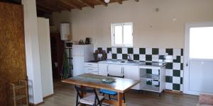 a kitchen with a table and a small kitchen with a table and chairs at Casa do Meio in Nadadouro +7 photos