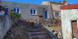 a house with stairs in front of a house at Casa do Meio in Nadadouro
