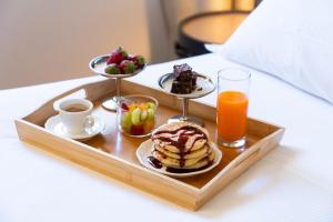 a tray with breakfast foods and drinks on a bed at Hotel Regina in Milan