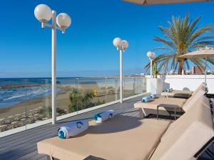 a row of tables on a balcony with the beach at Don Gregory by Dunas - Adults Only in San Agustin +37 photos