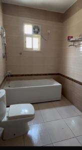 een badkamer met een ligbad en een toilet bij New Elite المنسك الجديد in Abha