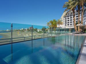 a large swimming pool with palm trees and a building at Don Gregory by Dunas - Adults Only in San Agustin