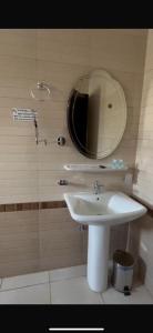 een badkamer met een wastafel en een spiegel bij New Elite المنسك الجديد in Abha +2 foto's