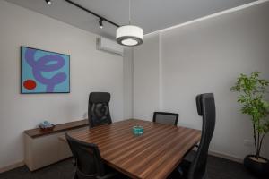 an office meeting room with a wooden table and chairs at Livingville East Aparthotel in Cairo