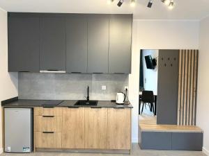 a kitchen with wooden cabinets and stainless steel appliances at Apartamenty Sokół in Drohiczyn