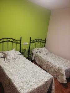 two beds in a room with green walls at La Parra  +23 photos