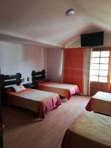 a hotel room with two beds and a window at La Parra 