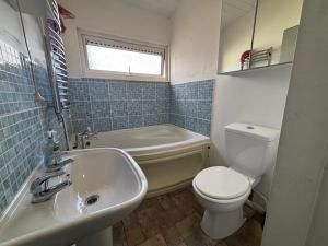a bathroom with a sink and a toilet and a tub at Shared Home - Self Check-In - Resident Cat in Hatfield