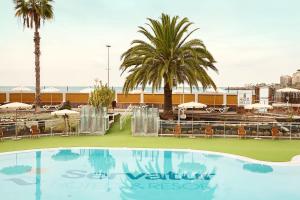 a swimming pool with palm trees and a resort at Servatur Green Beach in La Playa de Arguineguín