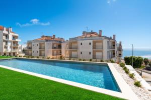 una piscina frente a unos edificios de apartamentos en T3 Mar de Prata, en Nazaré
