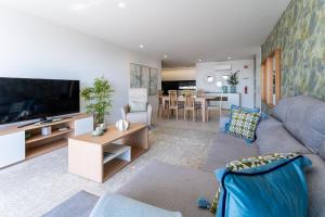 Una sala de estar con un sofá y un televisor. en T3 Mar de Prata, en Nazaré