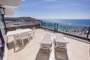 a balcony with a table and chairs and the ocean at Servatur JB - Adults Only in Puerto Rico de Gran Canaria