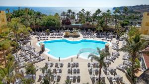 eine Luftaufnahme eines Resorts mit Pool und Stühlen in der Unterkunft Sport Hotel Monte Feliz - powered by Playitas in Playa del Aguila