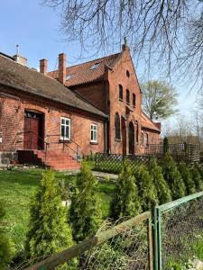 an old brick house with christmas trees in front of it at STARA KAMIENICA in Reszel