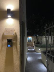 a sign on the side of a wall with a light at La Casa Del Monsignore in Torre del Greco