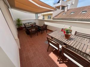 a patio with a wooden table and chairs on a balcony at Apartamentos Rincón del Mar in Torre del Mar