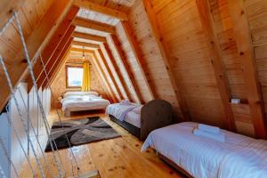 a room with three beds in a log cabin at WIND Cottage in Žabljak