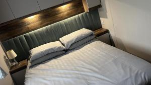 a bed with two pillows on it in a bedroom at Wiseman Bridge Caravan Retreat- Minutes to Beach in Narberth +8 photos
