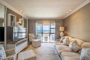 a living room with a couch and a television at Beach life in Summerstrand