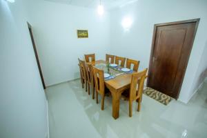 a dining room with a table and chairs and a door at Villa Enchanté - Apartment in Nugegoda 2BR in Talapatpitiya