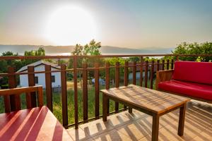 a red chair and a table on a deck at Sunset Villa Apartments in Ohrid