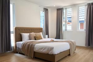 a bedroom with a bed with white sheets and windows at Luxury Pool Villa in the Heart of the Chiang Mai in Chiang Mai +26 photos