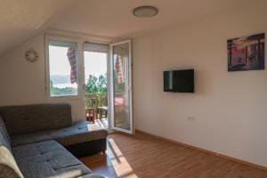 a living room with a couch and a tv at Sunset Villa Apartments in Ohrid