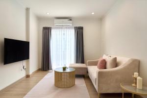 a living room with a couch and a tv at Luxury Pool Villa in the Heart of the Chiang Mai in Chiang Mai