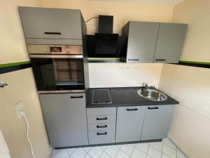 a small kitchen with a sink and a microwave at Ferienwohnung Stadtzauber in Malchow