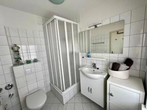 a white bathroom with a sink and a toilet at Ferienwohnung Stadtzauber in Malchow