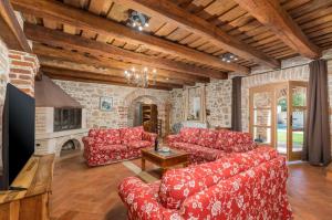 a living room with red couches and a fireplace at Villa Lamija by Villsy in Krmenjak