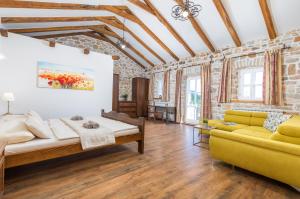 a living room with a yellow couch and a brick wall at Villa Lamija by Villsy in Krmenjak +50 photos