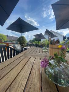 a vase of flowers on a wooden table with umbrellas at Landgasthof zur Leonie - Wirtshaus & Boutiquehotel 