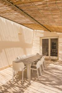 a wooden table and chairs on a patio at Villa Ginevra- Private Pool in Orosei
