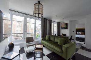 a living room with a green couch and a table at O'Lord, 4 Etoiles, Residence de Luxe Champs-Elysees in Paris