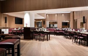 Un restaurante con mesas y sillas y un bar. en Stadthotel am Römerturm, en Colonia