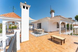 un patio con una mesa y un banco en una casa en VB Villa Coto 7BR w Pool & Views, en Santa Fe de los Boliches