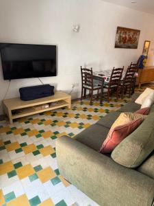 Una sala de estar con un sofá y una mesa con sillas. en Sliema Room, en Sliema 1 foto más