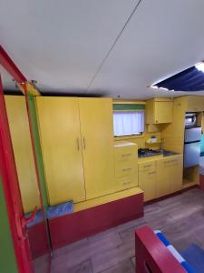 a kitchen with yellow cabinets and a red bench at R&B carvan in Eilat