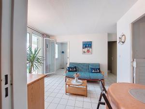 a living room with a blue couch and a table at Apartment Parc de Pontaillac-10 by Interhome in Pontaillac