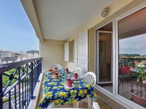a table and chairs on a balcony with a table and a view at Apartment Parc de Pontaillac-10 by Interhome in Pontaillac