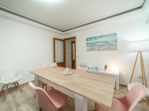 a dining room with a wooden table and pink chairs at Villa Villa Rosa by Interhome in Port d'Alcudia