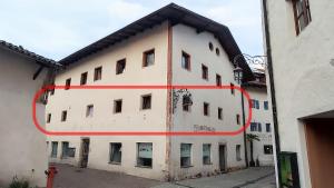 a white building with a red circle on it at Große Wohnung mit Garagenparkplatz in Vols am Schlern