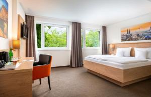 Una habitación de hotel con una cama, un escritorio y dos ventanas. en Stadthotel am Römerturm, en Colonia 21 fotos más