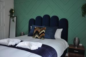 a bedroom with a large bed with a blue headboard at Modern 2-Bed Apartment, The Hub MK, Free Parking & Smart TV in Milton Keynes +9 photos