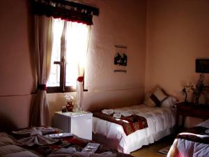 a living room with two beds and a window at Hotel Norte Rupestre in Tilcara